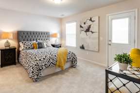 A bedroom with a bed, nightstand, and a painting on the wall.