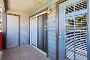 A blue door with a window and a white door to the left.