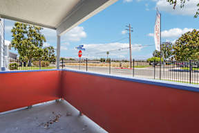 A red wall with a white ceiling and a fence in the background.
