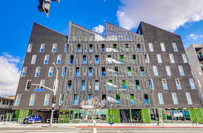 A modern building with a mix of dark and light grey panels.