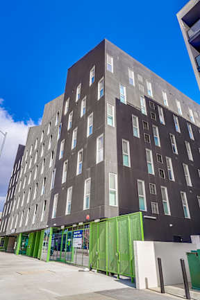 A tall building with a green door at the bottom.
