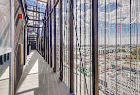 A long corridor with a view of the city through the windows.