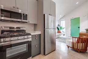 A modern kitchen with a stainless steel refrigerator and oven.