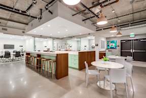 A modern kitchen with a bar area and a dining table.
