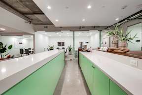 A modern office with green and white counters.