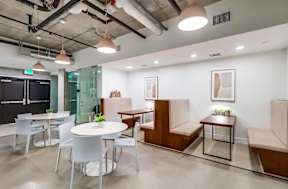 A modern office space with a glass wall and a blackboard.