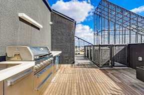 A modern outdoor kitchen with a grill and a barbecue oven.