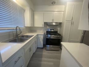 A kitchen with white cabinets and a stainless steel oven.
