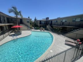 the view of a swimming pool at an apartment building with a pool