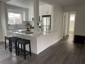a kitchen with an island and three stools in it