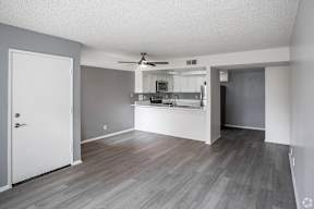 A kitchen with a white door and a fan on the ceiling.