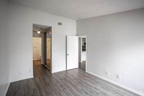 A room with a white wall and a wooden floor.