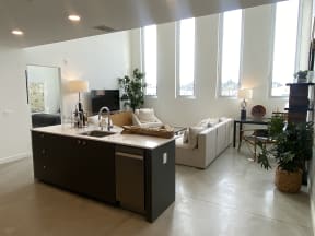 an open kitchen and living room with a couch and a sink
