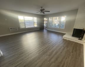 an empty living room with wood floors and a fireplace