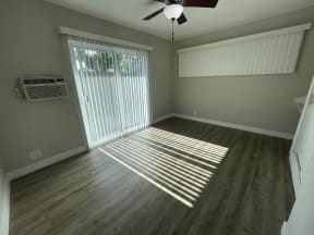 an empty living room with a sliding glass door and a window