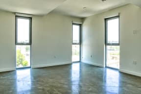 an empty living room with white walls and a concrete floor