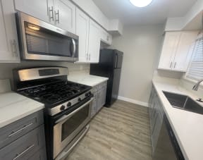 a kitchen with white cabinets and a stove and a microwave