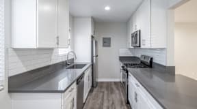A modern kitchen with white cabinets and stainless steel appliances.