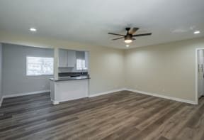A room with a ceiling fan and wooden flooring.