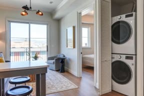 a laundry room with a washer and dryer and a door to a bedroom