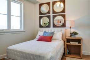 a bedroom with a white bed and mirrors on the wall