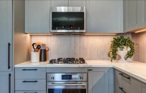 a kitchen with white cabinets and a stove and a microwave