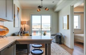 a kitchen and living room with a door to a balcony