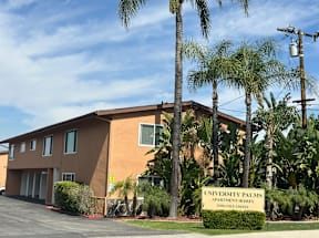 A building with a sign that says University Palms Apartment Homes.
