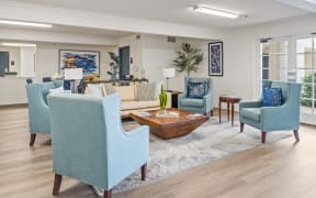 a living room with blue chairs and a couch and a coffee table