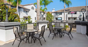 a patio with tables and chairs on a balcony