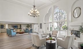 a living room with white furniture and large windows