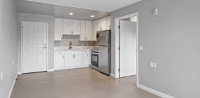 a kitchen with white cabinets and a stainless steel refrigerator