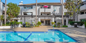 a swimming pool in front of a white building with a pool