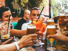 young adults toasting glasses of beer and cocktails