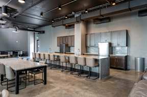 A modern kitchen with a long table and chairs.