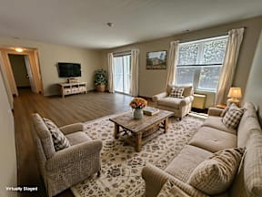 A living room with a couch, chairs, and a coffee table.