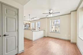 A room with a ceiling fan and a door.