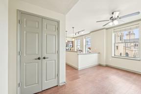 A room with a white door and a ceiling fan.