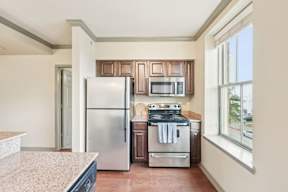 A kitchen with a refrigerator, oven, and microwave.