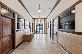 A hallway with a bench and a sign that says "Keller Realty Inc."