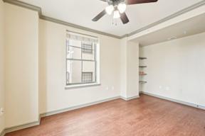 A room with a ceiling fan and a window.