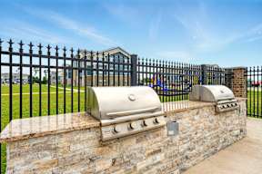 A wall of stone with two built in BBQs.