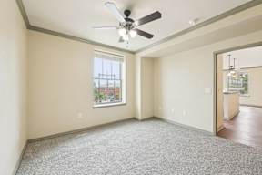 A room with a ceiling fan and a window.