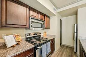 A kitchen with a stove, microwave, and refrigerator.