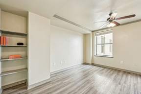 A room with a ceiling fan and a window.