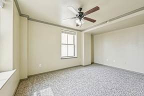 A room with a ceiling fan and a window.