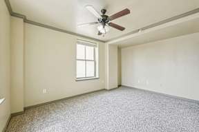A room with a ceiling fan and a window.