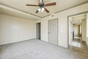 A room with a ceiling fan and two doors.