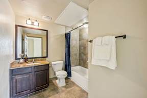 A bathroom with a toilet, sink, and shower.