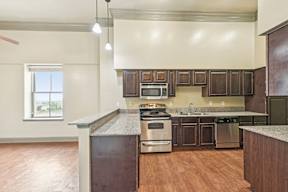 A kitchen with wooden cabinets and a stainless steel oven.